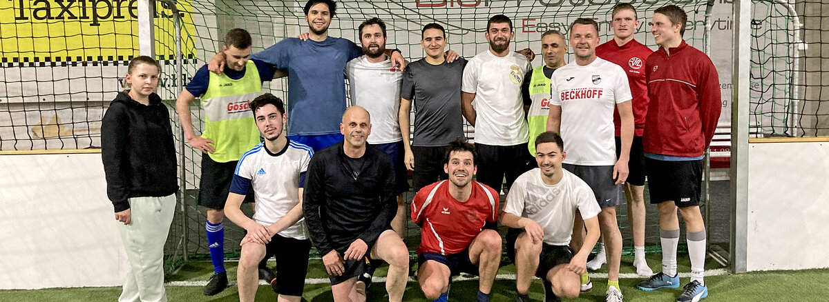 Das Bild zeigt Mitarbeiter beim gemeinsamen Posieren beim Fussball.