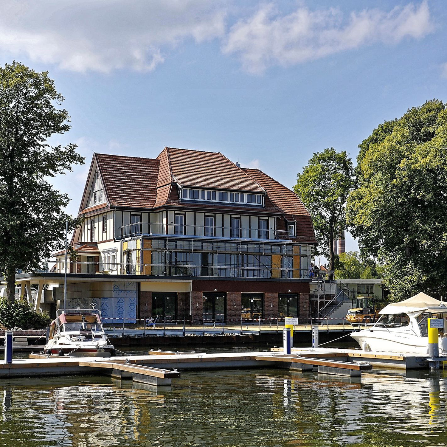 Steganlage Aufnahme eines Klubhauses am See mit Booten und Wasser.